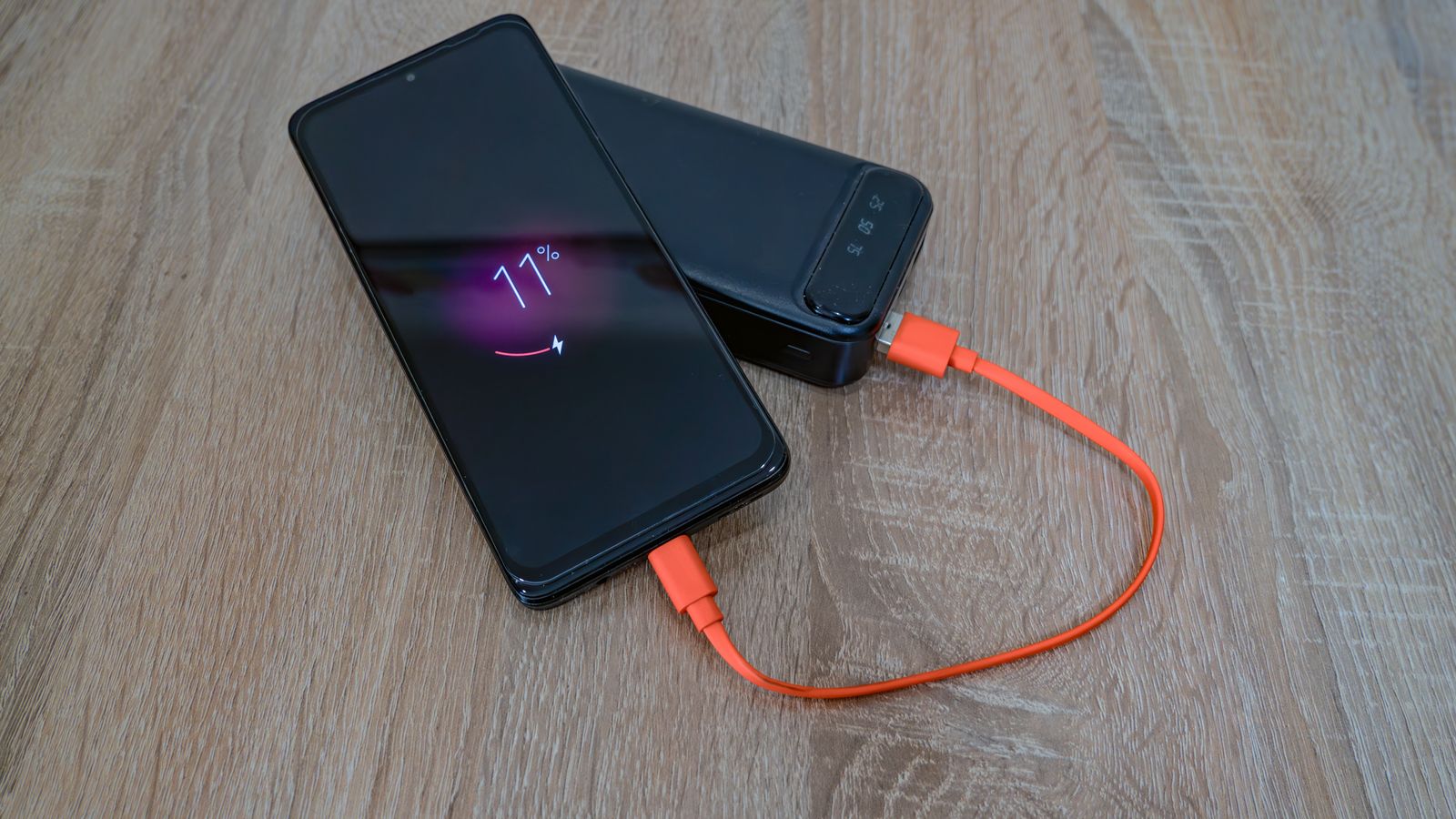 A smartphone charging from a portable power bank